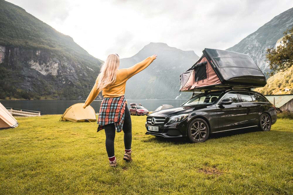 campwerk-test-camping-vergleich-mobiles-zuhause-urlaub-erfahrungen-dachzelt-auto-aufbau-skycamp-ikamper-berge-alpen-ausflug-mercedes-limusine-frau-tanzt-see-bergsee