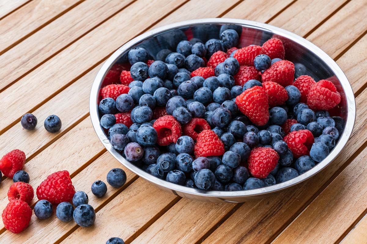 beeren-beere-smoothe-gesund-schale-holz-tisch-mix-blaubeeren-himbeeren-vitamine